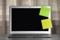 Laptop with blank sticky notes on grey office desk. Space for text Royalty Free Stock Photo