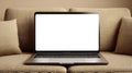 Laptop with a blank white screen placed on a beige fabric sofa. The sofa features Royalty Free Stock Photo