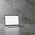 A laptop with a blank white screen sits on a textured dark gray surface. To the right, a Royalty Free Stock Photo