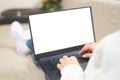 Laptop with blank white screen. woman working and typing on laptop computer with blank screen while lying on a sofa at home. Royalty Free Stock Photo