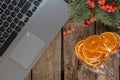 Laptop branch of a Christmas tree viburnum dried orange on a wooden table, Christmas