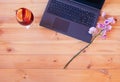 Laptop, branch of orchid and glass of sangria on wooden table