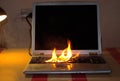A laptop burns on a table in a room Royalty Free Stock Photo