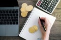 Laptop with calculator and golden bitcoin. Cryptocurrency invest