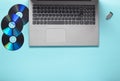 Laptop, CD drives, USB flash drive on a blue background. Modern and outdated digital media Royalty Free Stock Photo