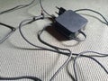 Laptop charger with its messy cable on a structured surface Royalty Free Stock Photo