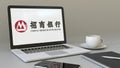 Laptop with China Merchants Bank logo on the screen. Modern workplace conceptual editorial 3D rendering