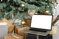 Laptop. Christmas tree and gifts on background