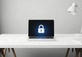 Laptop on a clean desk displaying a large glowing padlock symbol on its screen Royalty Free Stock Photo