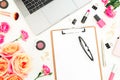 Laptop with clipboard, glasses, roses flowers, cosmetics and accessories on white background. Flat lay. Top view. Women freelancer Royalty Free Stock Photo