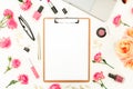 Laptop, clipboard, roses flowers, cosmetics and accessories on white background. Flat lay. Top view. Feminine office or blogger co Royalty Free Stock Photo