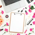 Laptop, clipboard, roses flowers, cosmetics and accessories on white background. Flat lay. Top view. Freelancer office composition Royalty Free Stock Photo