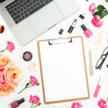 Laptop, clipboard, roses flowers and cosmetics on white background. Flat lay. Top view. Freelancer composition Royalty Free Stock Photo