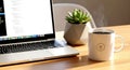 Laptop coding session with steaming coffee and geometric succule Royalty Free Stock Photo