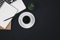 Laptop, coffee cup and notepad on black background, top view. Royalty Free Stock Photo