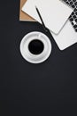 Laptop, coffee cup and notepads on black background, top view. Royalty Free Stock Photo