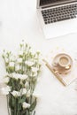 Laptop, coffee, notebook and a large bouquet white flowers on the floor on a white fur carpet. Freelance fashion comfortable femin Royalty Free Stock Photo