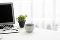 Laptop computer with blank mock up screen is on top of white office desk table with supplies Royalty Free Stock Photo