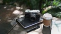 Laptop computer with blank screen, coffee cup and notebook on wooden table at outdoor. Royalty Free Stock Photo