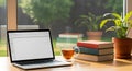 Modern Workspace with Laptop, Tea, and Books Royalty Free Stock Photo