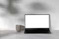 Laptop computer with blank white display mockup, concrete candle on neutral gray marble desk background, white plaster Royalty Free Stock Photo