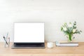 Laptop computer with blank white screen, unicorn, bouquet of flowers on office workplace. Feminine home office desk table. Stylish