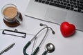 Laptop, clipboard, stethoscope and red heart on white background. Health insurance concept. Royalty Free Stock Photo