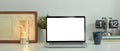 Laptop computer, coffee cup, picture frame and potted plant on white table. Blank screen for text information or content Royalty Free Stock Photo