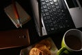 Laptop computer, cup of coffee, ballpen, notebook, crackers, and a smartphone Royalty Free Stock Photo
