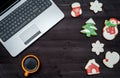 Laptop computer, cup of coffee and gingerbread cookies on dark wood background, copy space. Top view, flat lay. Christmas texture. Royalty Free Stock Photo