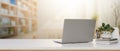 A laptop computer, decor, and space on a white table with a blurred background of a bright library Royalty Free Stock Photo