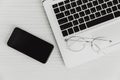 Laptop computer on the desk with smartphone and glasses top view monotone for minimal business flat lay picture