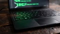 Laptop computer displaying green programming code on screen and keyboard on a dark wooden table Royalty Free Stock Photo