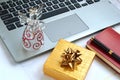 Laptop computer with a glass angel and a yellow golden gift box Royalty Free Stock Photo