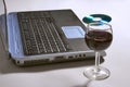 Laptop computer with a glass of wine and CD. Royalty Free Stock Photo