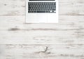 Laptop computer keyboard over wooden desk. Office background