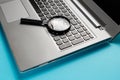Laptop computer with magnifying glass on blue background, concept of search Royalty Free Stock Photo
