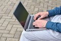 Laptop computer and man hands while working remotely on the computer outdoors. Royalty Free Stock Photo