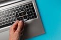 Laptop computer and man`s hand with magnifying glass on blue background, concept of search Royalty Free Stock Photo