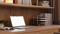 A laptop computer mockup and office supplies on a wooden desk in a modern office workspace Royalty Free Stock Photo