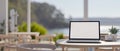 A laptop computer mockup on a table in a beautiful contemporary cafe or restaurant by the beach Royalty Free Stock Photo