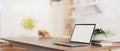 A laptop computer mockup on a wooden kitchen island tabletop in a modern bright kitchen Royalty Free Stock Photo