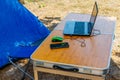 Laptop with computer mouse and smartphone on a folding picnic table in a camping. Working while traveling. Freelance work Royalty Free Stock Photo