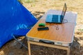 Laptop with computer mouse and smartphone on a folding picnic table in a camping. Working while traveling. Freelance work. Work Royalty Free Stock Photo