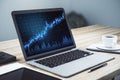 Laptop computer on office table with statistics on screen