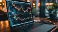 A laptop computer is open to a screen displaying a graph of stock prices Royalty Free Stock Photo