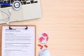 Laptop computer and pill with blue stethoscope on wooden desk. Royalty Free Stock Photo