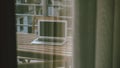 Laptop computer shut down on hotel room balcony seen through room window, working on vacation Royalty Free Stock Photo