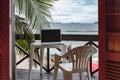 Laptop computer on a table in a tropical balcony near the sea-working from home vacation concept