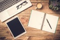 Laptop, computer tablet and open note book with white copy space on a rustic wooden table. Office work, workspace and desk top Royalty Free Stock Photo